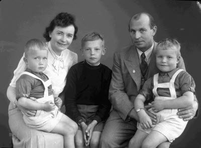 Porträtt av en herre och en dam med tre barn, pojkar. Ateljefoto.