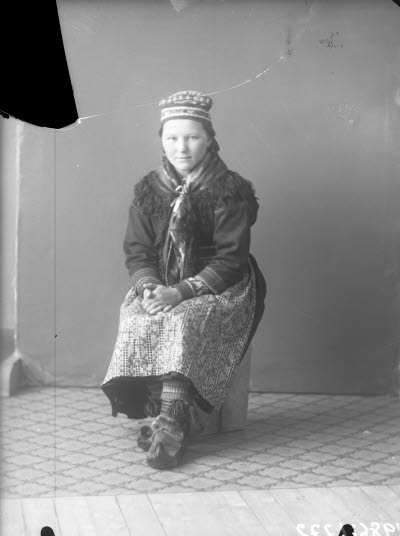 Porträtt av en dam i samedräkt. Ateljefoto.