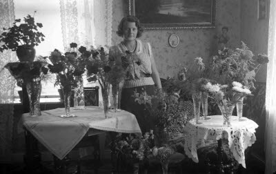 Födelsedagsfirande? Interiör vardagsrum med blomstersmyckade bord.