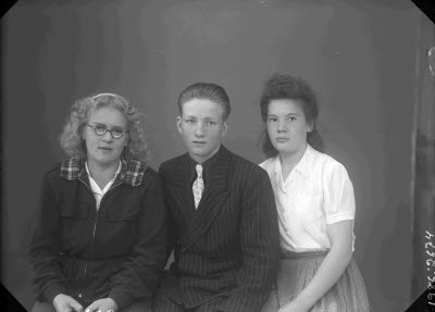 Porträtt av två damer och en herre.