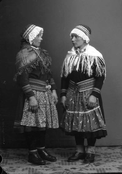 Porträtt av två damer i samedräkter. Ateljefoto.