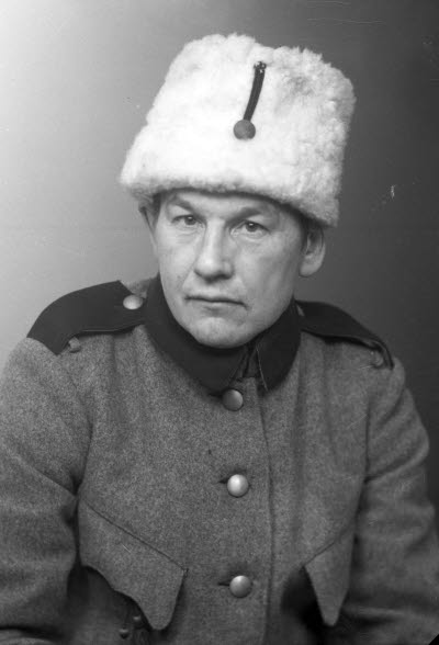 Porträtt av en herre i uniform och pälsmössa. Ateljefoto.