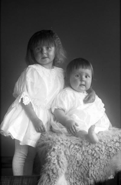 Porträtt av 2 barn, flicka. Ateljefoto.