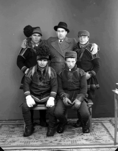 Porträtt av fem herrar, varav fyra i samedräkter. Ateljefoto.