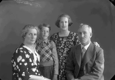 Porträtt av en herre, en dam och två barn; flicka och pojke. Ateljefoto.