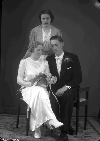 Porträtt av ett brudpar; brudtärna. Ateljefoto.