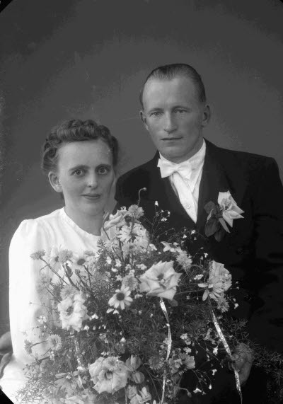 Porträtt av ett brudpar; en herre och en dam. Ateljefoto.