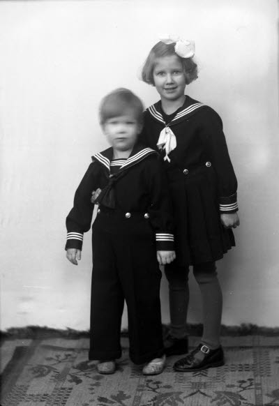 Porträtt av två barn; flicka och pojke. Ateljefoto.