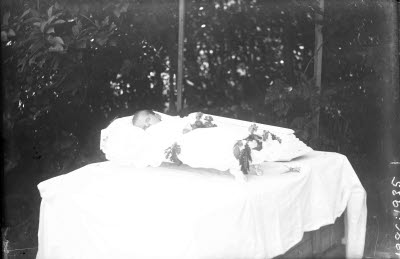 Svepning; avlidet barn i öppen kista. Oidentifierad.