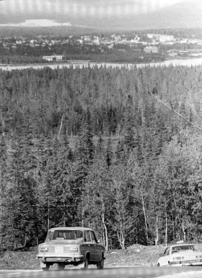 Personbilar efter Dundretvägen, Gällivare. Gällivare samhälle och Vassaraälven.