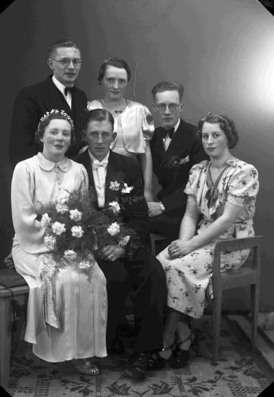 Porträtt av ett brudpar samt två herrar och två damer. Ateljefoto.