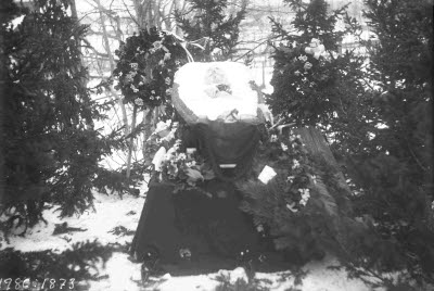 Öppen kista. En herre. Oidentifierad. Kransar och blommor.