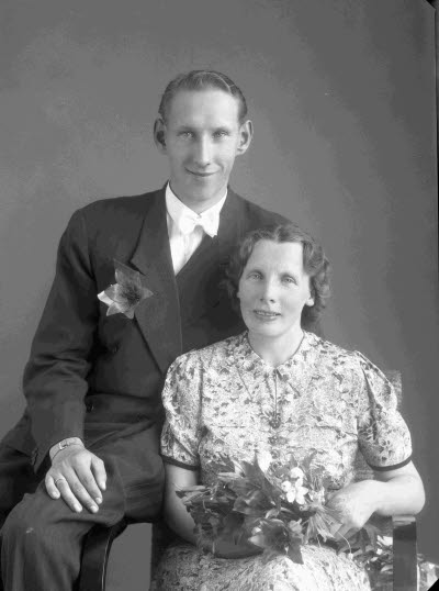 Porträtt av ett brudpar; en herre och en dam. Ateljefoto.