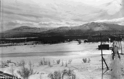 Gångbron över Vassaraälven mot barnhemmet. Dundret i bakgrunden.