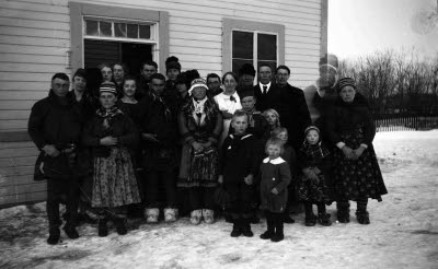 Gruppbild framför skolbyggnad. Samedräkter.
