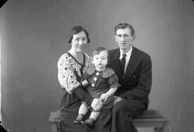 Porträtt av en herre och en dam med ett barn. Ateljefoto.