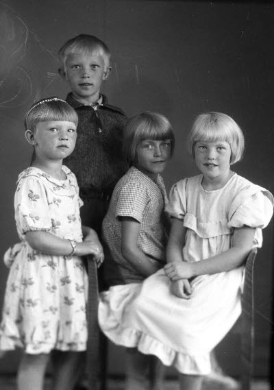 Porträtt av fyra barn; en pojke och tre flickor. Ateljefoto.