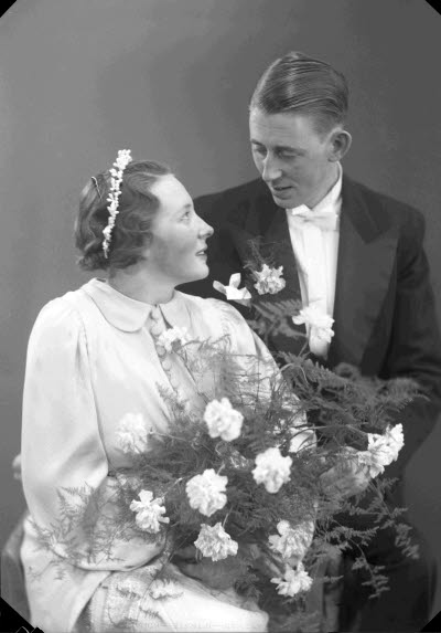 Porträtt av ett brudpar; en herre och en dam. Ateljefoto.