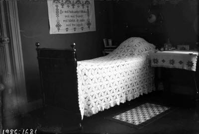 Fransk järnsäng med virkat överkast.