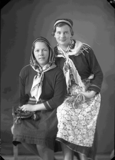 Porträtt av två damer i folkdräkt. Ateljefoto.