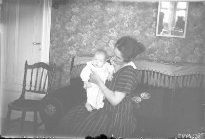 En kvinna och ett barn i hemmiljö. Vardagsrum.