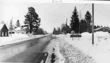Vägskylt; ortnamnsmärke Junosuando. Småort; by. Landsväg, bebyggelse; hus.