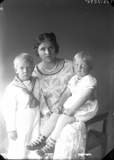 Porträtt av 1 kvinna och 2 barn. Ateljefoto.