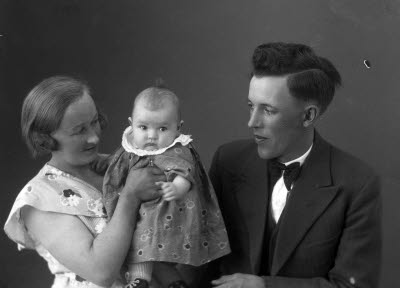 Porträtt av en herre och en dam med ett barn. Ateljefoto.