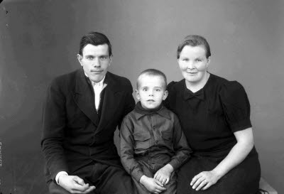 Porträtt av en herre och en dam med ett barn, en pojke. Ateljefoto.