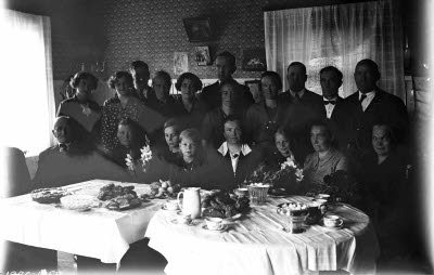 En grupp människor vid dukade bord; födelsedag? Oidentifierade.