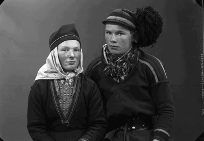 Porträtt av ett par; en herre och en dam i samedräkter. Ateljefoto.