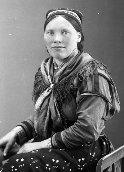 Porträtt av en dam i samedräkt. Ateljefoto.