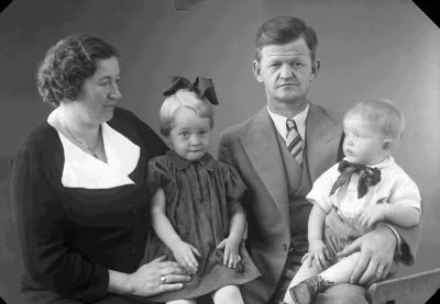 Porträtt av en herre, en dam och två barn; flicka, pojke. Ateljefoto.