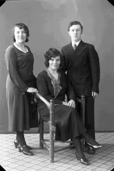 Porträtt av två damer och en herre. Ateljefoto.