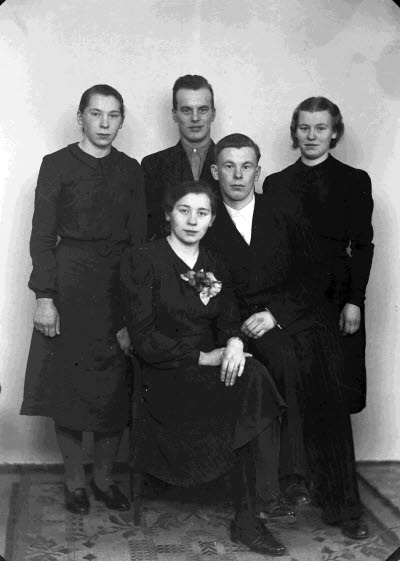 Porträtt av ett brudpar samt en herre och två damer. Ateljefoto.