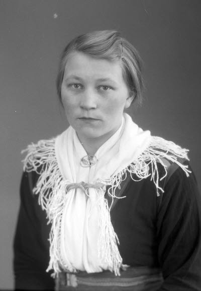 Porträtt av en ung dam i samedräkt. Ateljefoto.