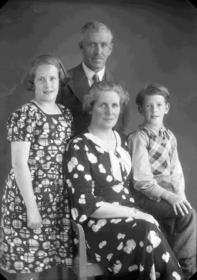 Porträtt av en herre, en dam och två barn; pojke och flicka. Ateljefoto.