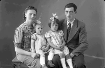 Porträtt av en herre och en dam med två barn, flickor. Ateljefoto.