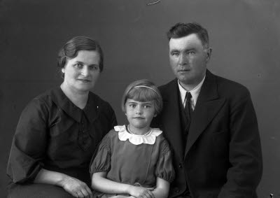 Porträtt av en herre, en dam och ett barn; flicka. Ateljefoto.