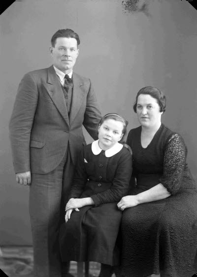 Porträtt av en herre, en dam och ett barn, flicka. Ateljefoto.