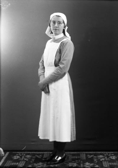 Porträtt av en dam i sköterskeuniform. Ateljefoto.