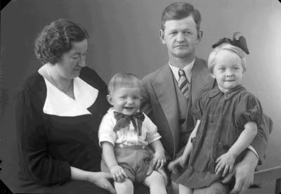 Porträtt av en herre, en dam och två barn; flicka, pojke. Ateljefoto.