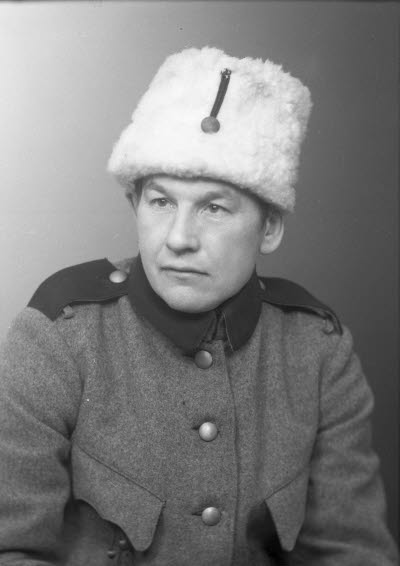 Porträtt av en herre i uniform och pälsmössa. Ateljefoto.