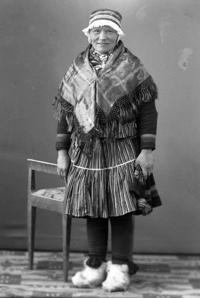 Porträtt av en dam i samedräkt. Ateljefoto.