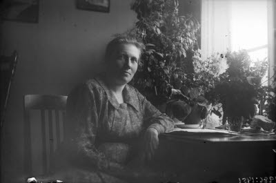 Äldre dam i hemmiljö. Vardagsrum.