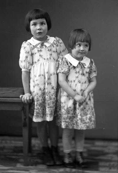 Porträtt av två barn, flickor. Ateljefoto.