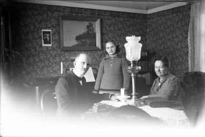 Ett äldre par och en flicka i hemmiljö.