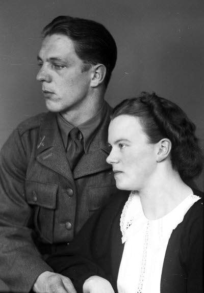 Porträtt av ett par; en herre i militäruniform och en dam. Ateljefoto.