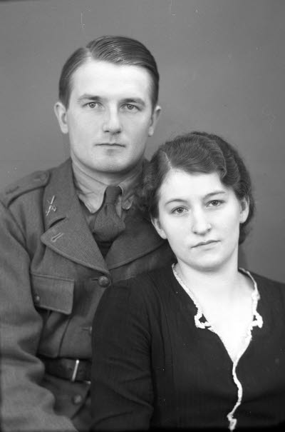 Porträtt av ett par; en herre i militäruniform och en dam. Ateljefoto.