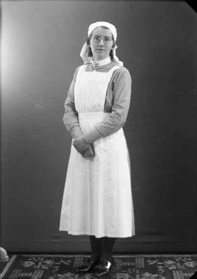 Porträtt av en dam i sköterskeuniform. Ateljefoto.